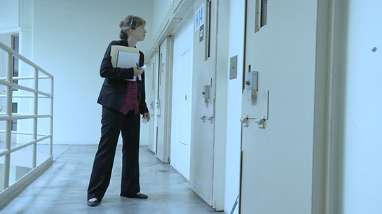 Rachael Seevers speaks with an inmate through a prison cell door.